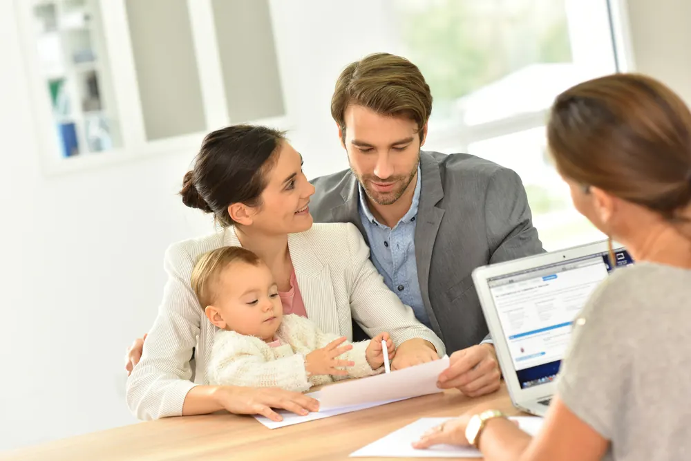 Parents with their baby talking with a Scholarship Saviour consultant